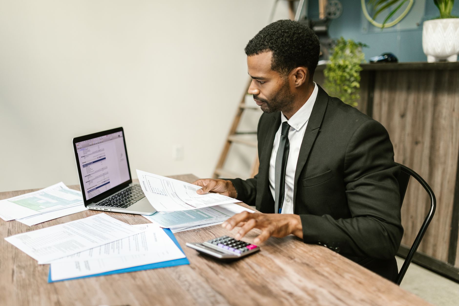 An accountant reviewing bank statements and spreadsheet data on a computer screen